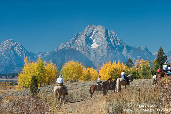 Image of horseback riders below Mount Moran in autumn, Grand Teton National Park