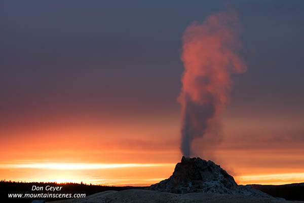 Image of White Dome Geyser erupting at sunset, Yellowstone National Park.